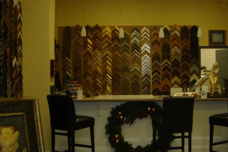 Rows of real-wood frame moulding samples inside Revere Picture Framing.