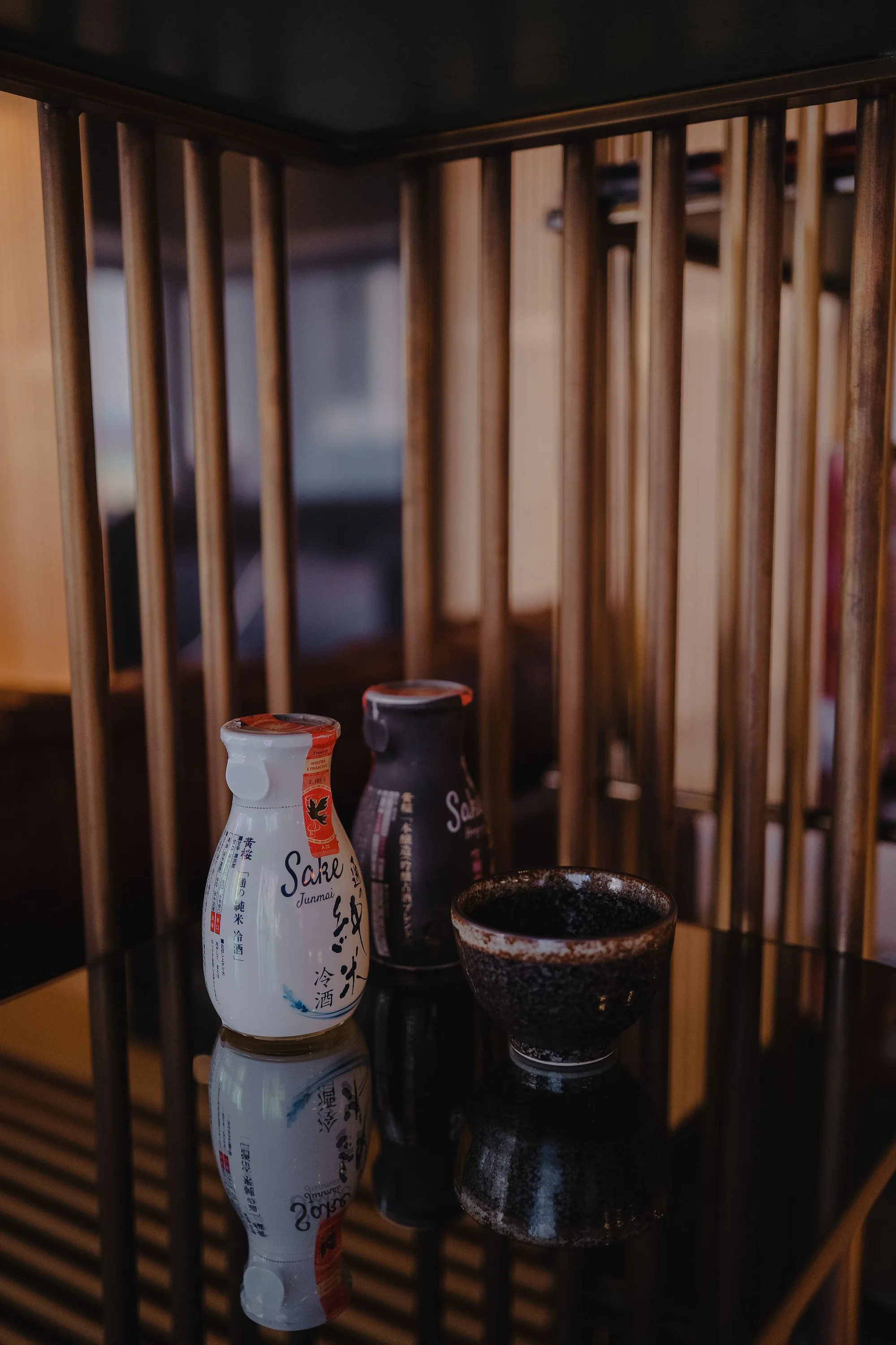 A ceramic sake service reflected on a polished counter.
